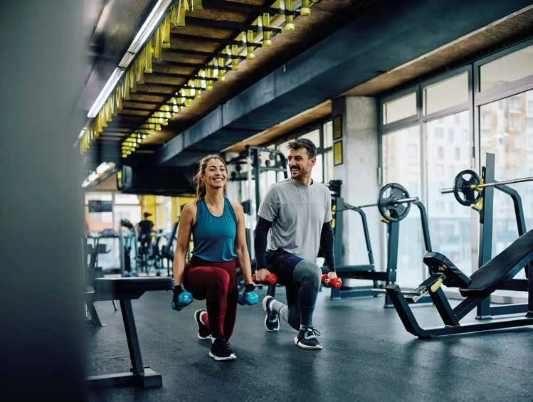 Dos personas realizando actividad física en un gimnasio